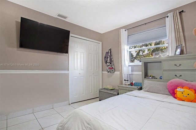 bedroom with light tile patterned floors and a closet