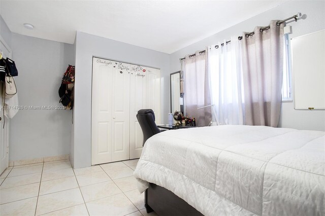 bedroom with light tile patterned flooring and a closet