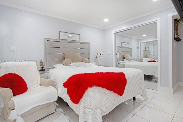 bedroom with tile patterned flooring, crown molding, and a closet