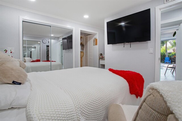 bedroom featuring access to outside, a closet, and ornamental molding