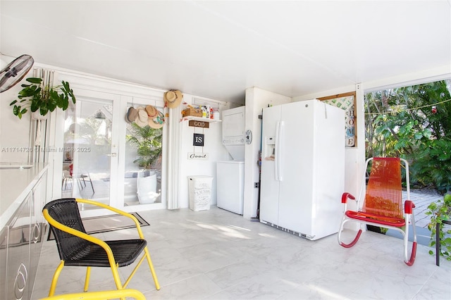 sunroom with stacked washing maching and dryer and french doors