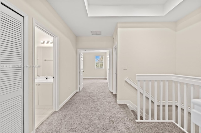 hallway with sink and light carpet