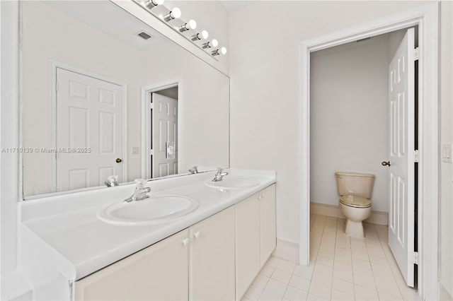 bathroom featuring tile patterned flooring, vanity, and toilet