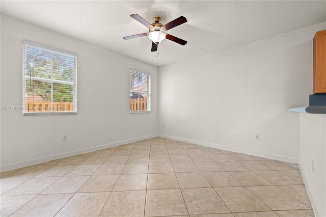 tiled spare room with ceiling fan