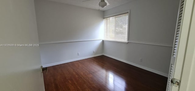 unfurnished room with ceiling fan, dark hardwood / wood-style flooring, and a textured ceiling