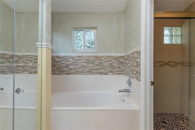 bathroom featuring shower with separate bathtub