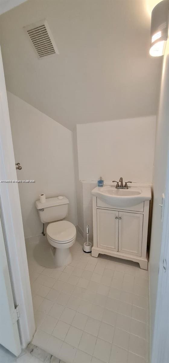 bathroom featuring tile patterned floors, vanity, and toilet