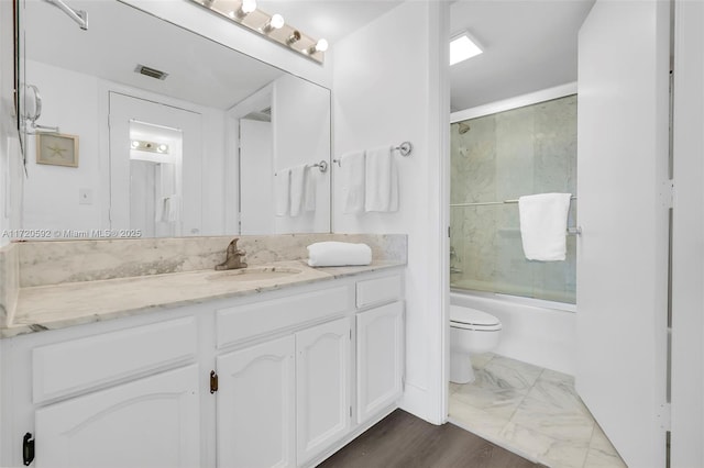 full bathroom featuring toilet, vanity, and combined bath / shower with glass door