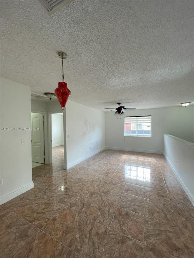 spare room with a textured ceiling and ceiling fan