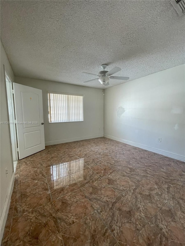 empty room featuring ceiling fan and a textured ceiling