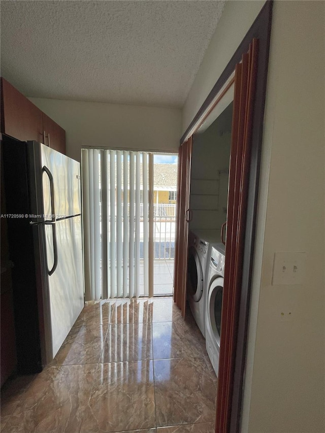 laundry room with a textured ceiling and separate washer and dryer