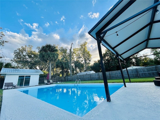 view of pool featuring an outbuilding and a patio area