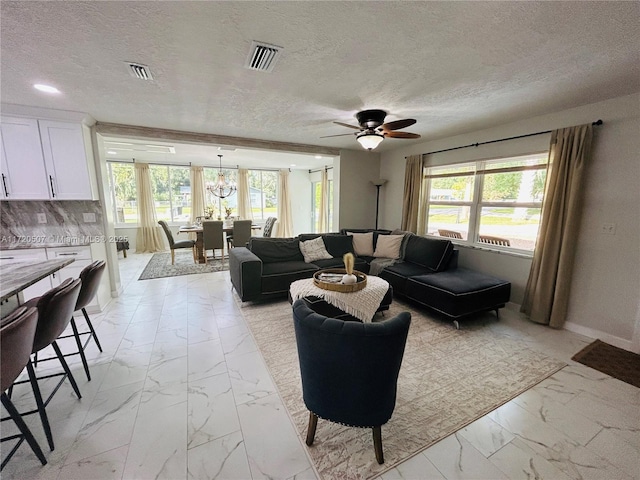 living room with ceiling fan and a textured ceiling