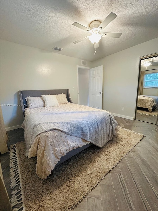 bedroom with ceiling fan and a textured ceiling