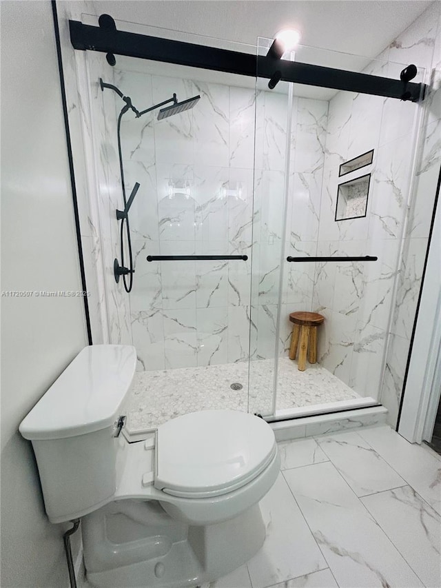 bathroom with toilet and a shower with door