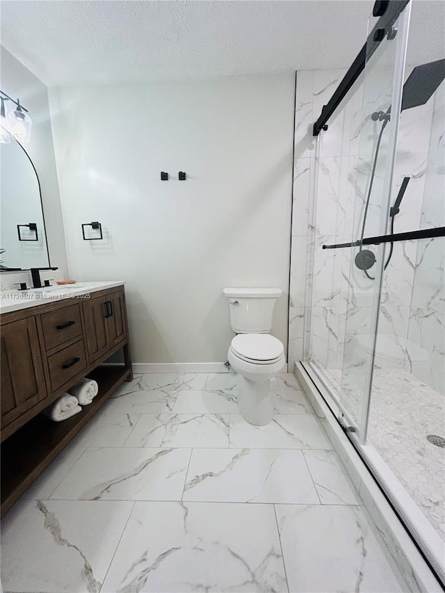 bathroom with vanity, toilet, a shower with shower door, and a textured ceiling