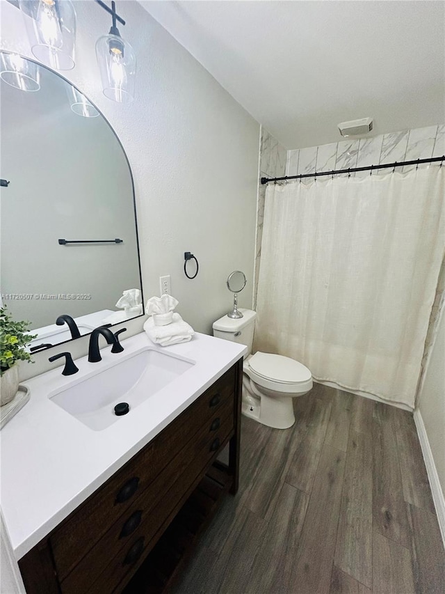 bathroom featuring a shower with shower curtain, vanity, hardwood / wood-style flooring, and toilet