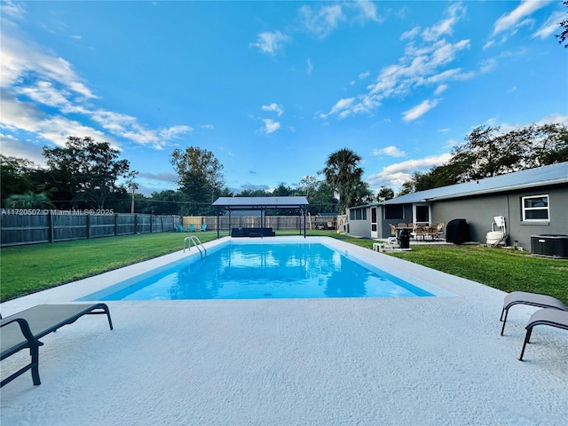 view of pool featuring central AC unit, a patio area, and a yard