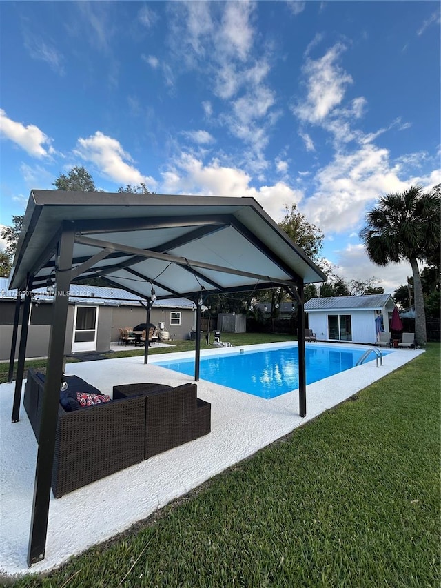 view of pool with an outdoor hangout area, a patio area, and a lawn