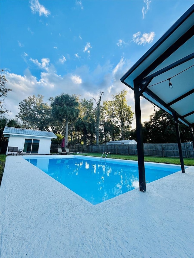 view of pool with an outbuilding