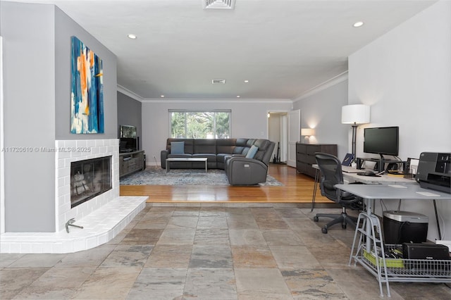 home office featuring crown molding, a fireplace, and light hardwood / wood-style floors