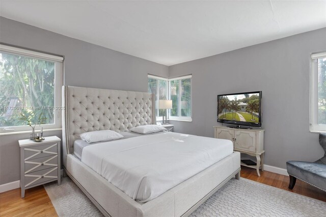 bedroom with hardwood / wood-style floors and multiple windows