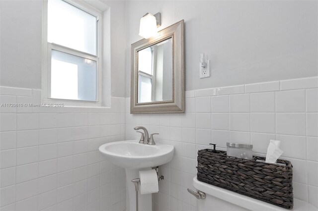 bathroom with toilet and tile walls