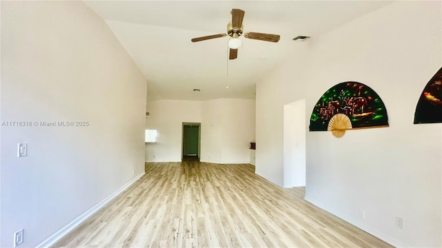 unfurnished room with a high ceiling, light wood-type flooring, and ceiling fan