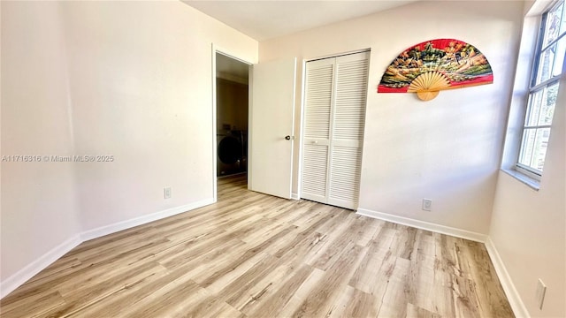 unfurnished bedroom featuring light wood-type flooring and a closet