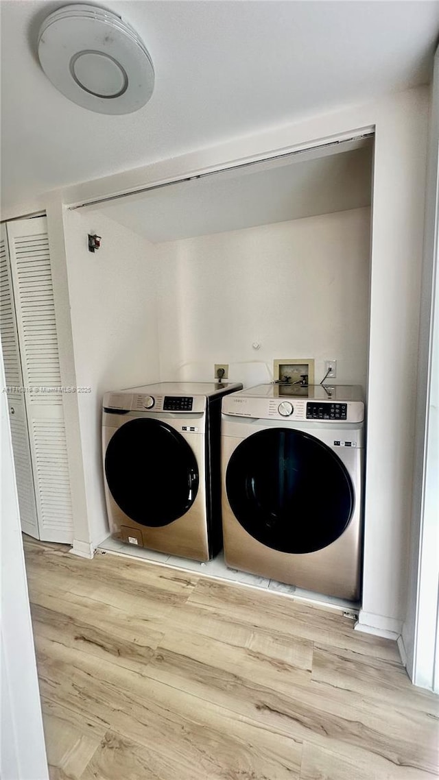 laundry area featuring washer and dryer and wood-type flooring