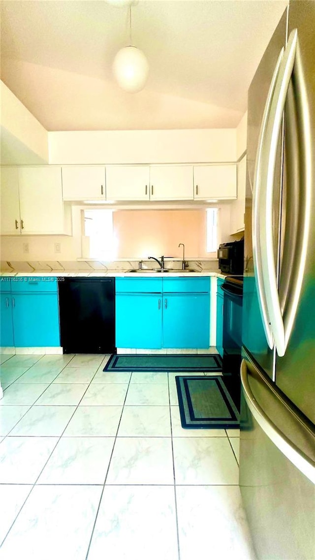 kitchen with sink, white cabinets, black appliances, and light tile patterned floors