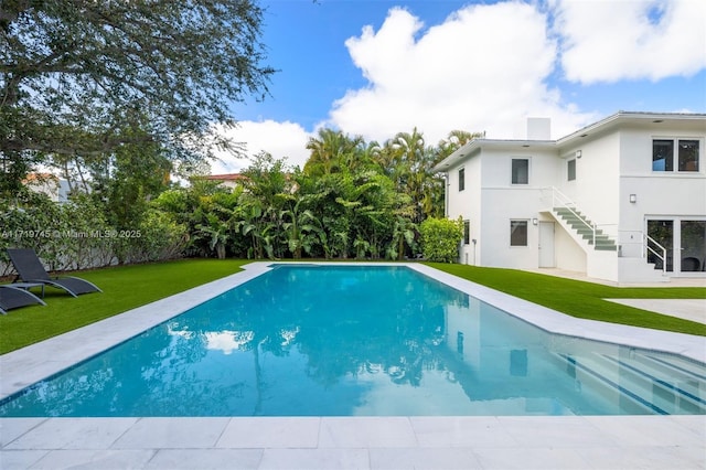 view of swimming pool with a yard