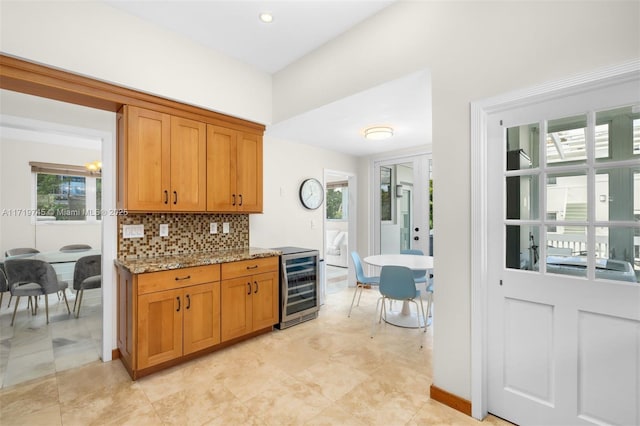 kitchen featuring light stone counters, a wealth of natural light, and wine cooler