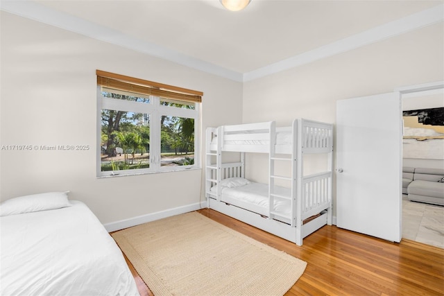 bedroom with hardwood / wood-style floors and ornamental molding