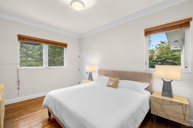 bedroom with hardwood / wood-style floors and crown molding