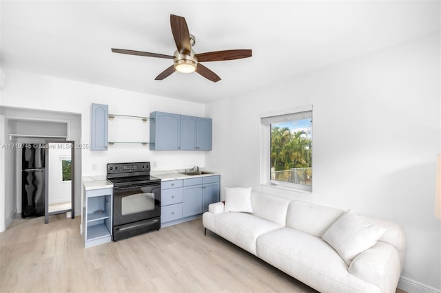 living room featuring sink, light hardwood / wood-style flooring, and ceiling fan