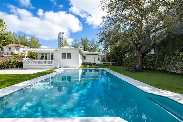 view of pool featuring a patio, a lawn, a pergola, and a trampoline