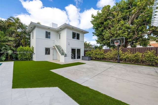 rear view of property featuring a patio and a lawn