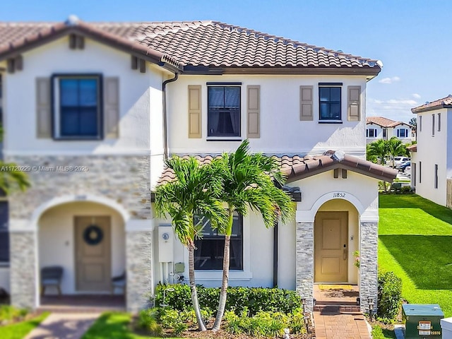 mediterranean / spanish home featuring a front lawn