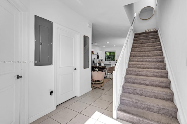 staircase featuring tile patterned flooring and electric panel