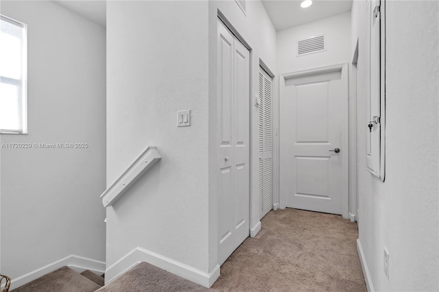 hallway with light colored carpet