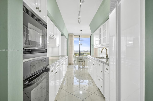 bathroom with tile patterned flooring, floor to ceiling windows, and sink