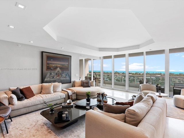 living room with a wall of windows and a tray ceiling