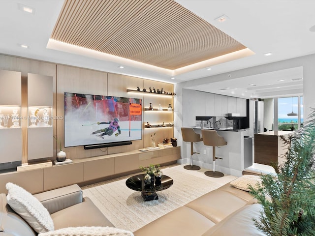 living area featuring recessed lighting and a raised ceiling