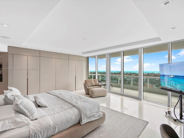 bedroom featuring access to exterior, visible vents, expansive windows, multiple windows, and a raised ceiling