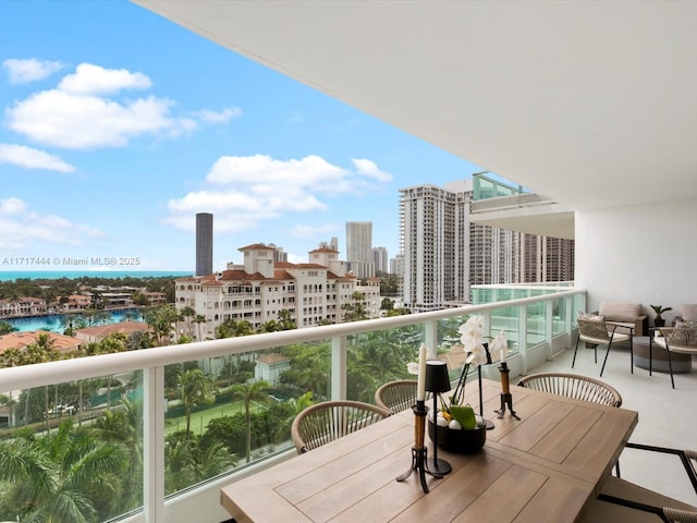balcony with outdoor dining area and a view of city