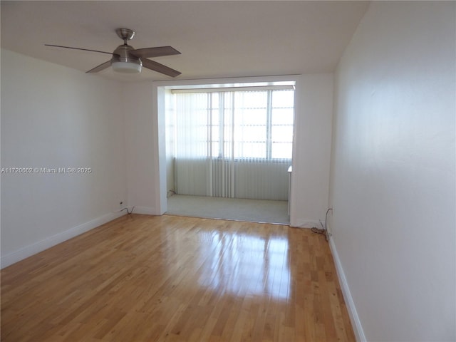 empty room featuring ceiling fan and light hardwood / wood-style flooring