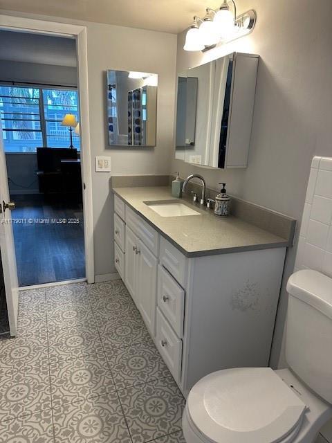 bathroom featuring toilet, an inviting chandelier, tile patterned flooring, and vanity