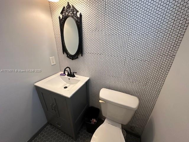 bathroom featuring toilet, vanity, and tile patterned flooring