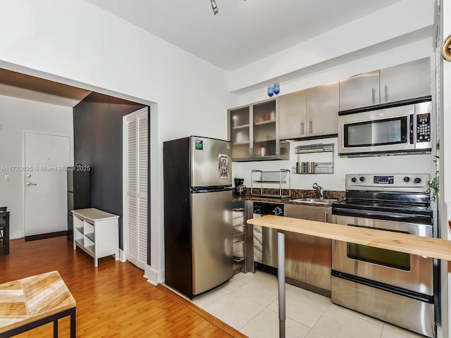 kitchen with light tile patterned flooring, sink, and stainless steel appliances